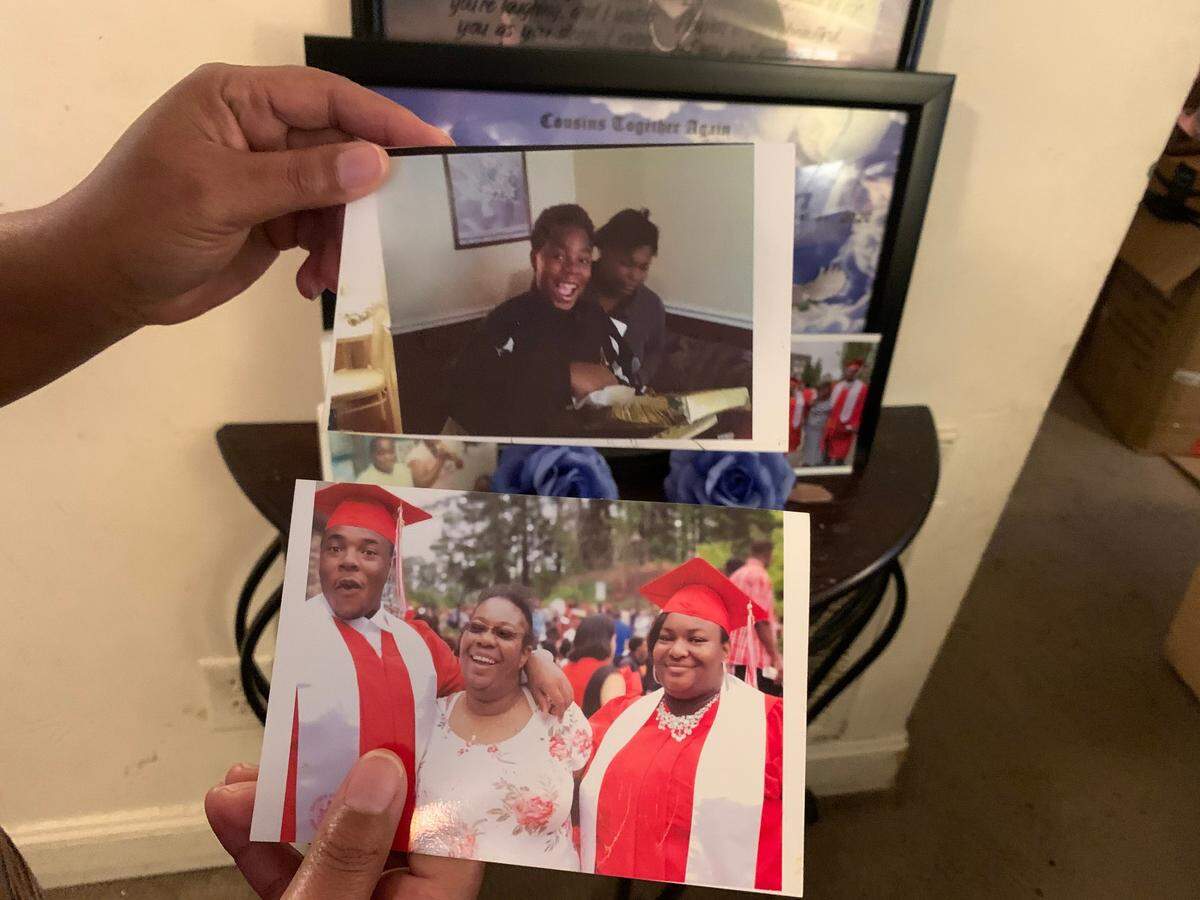 Nita Shaw holds up photos of her son, Amon Shaw, who was fatally shot in Durham in 2020.