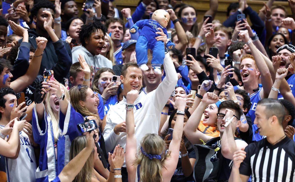 Duke head coach Jon Scheyer holds up a baby doll as he stands with the Cameron Crazies during the Blue Devils’ Countdown to Craziness at Cameron Indoor Stadium in Durham, N.C., Friday, Oct. 20, 2023.