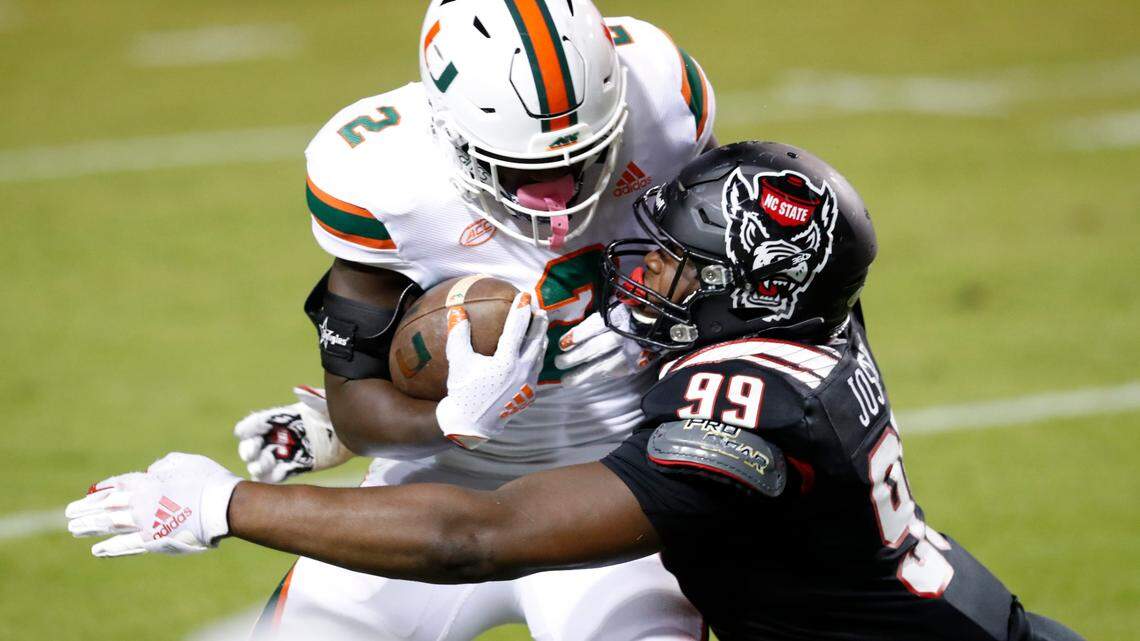 N.C. State defensive lineman Daniel Joseph (99) tackles Miami running back Donald Chaney Jr. (2) during the first half of N.C. State’s game against Miami at Carter-Finley Stadium in Raleigh, N.C., Friday, Nov. 6, 2020.