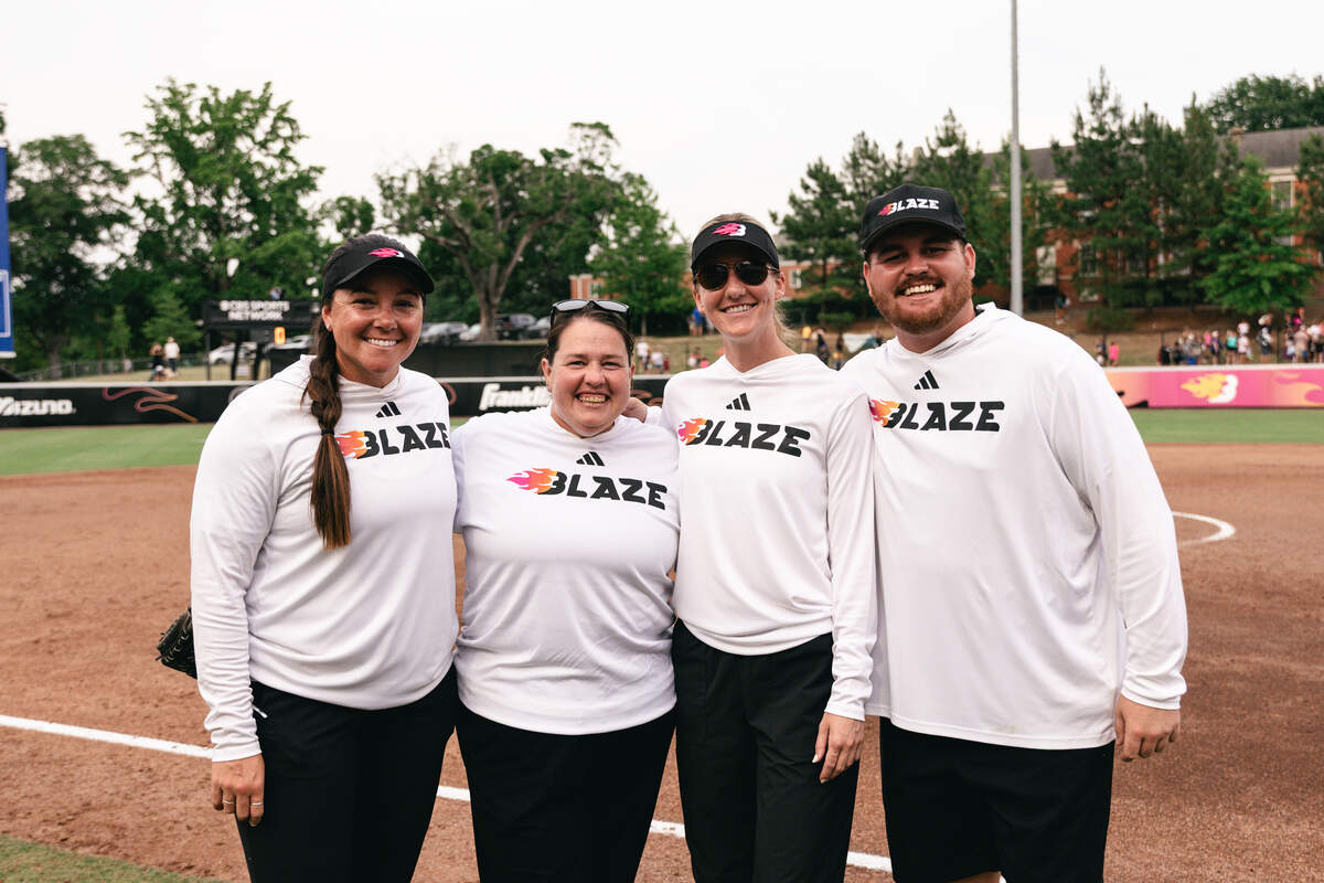 The Carolina Blaze coaching staff, from left, Brittany Cervantes, Lindsay Leftwich, Kara Dill and Kyler Holton, stands on the the field at Smith Family Stadium in Durham, North Carolina, before the team’s season opener on June 9, 2026. Leftwich also serves as the N.C. State head softball coach.