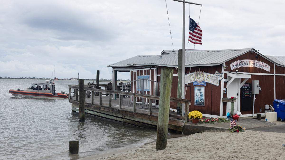 A Coast Guard boat patrols the Cape Fear River by American Fish Company in Southport, N.C., Sunday, Sept. 28, 2025.  A man in a boat opened fire from a boat Saturday evening killing three people at the popular nightspot. 