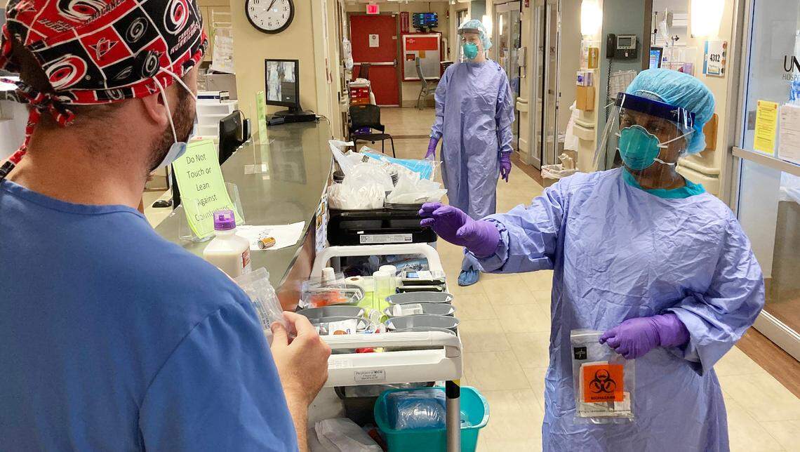 A nurse in a “safe area” prepares to hand medication to another nurse to be then be handed off to another working in a COVID patient’s room in the Medical Intensive Care Unit at UNC Hospital Wednesday, Juy 15, 2020.