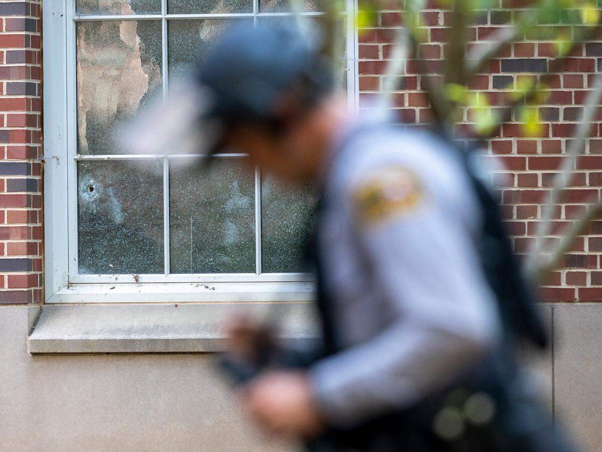 A North Carolina state trooper surveys the area outside Caudill Laboratories on the first floor of the building where a bullet broke a window on Monday, August 28. 2023 in Chapel Hill, N.C.