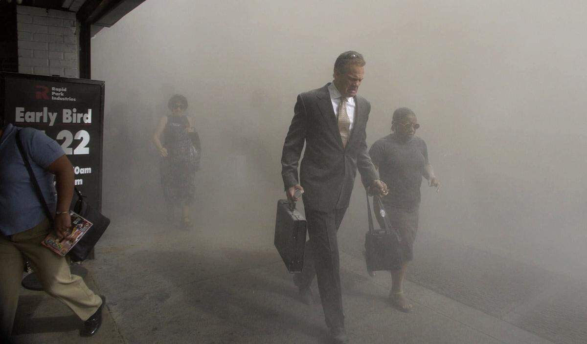 Pedestrians on Beekman St. flee the area of the collapsed World Trade Center in lower Manhattan following a terrorist attack on the New York landmark Tuesday, Sept. 11, 2001.