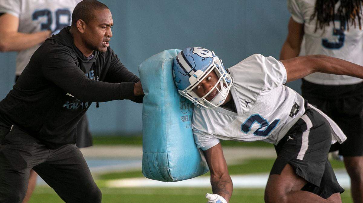 North Carolina cornerbacks coach Dre Bly works with defensive back Don Chapman (2) during the opening day of the Tar Heels’ spring football practice on Tuesday, March 1, 2022 in Chapel Hill, N.C.