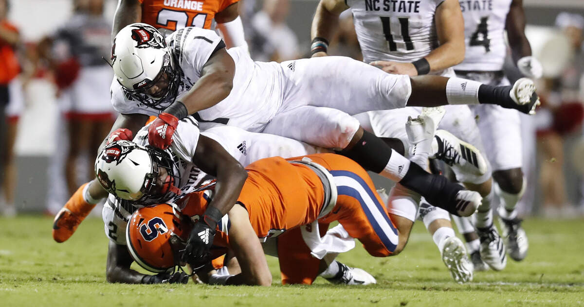 N.C. State linebacker Louis Acceus (2) sacks Syracuse quarterback Tommy DeVito (13) as James Smith-Williams (1) helps out during the first half of N.C. State’s game against Syracuse at Carter-Finley Stadium in Raleigh, N.C., Thursday, Oct. 10, 2019.