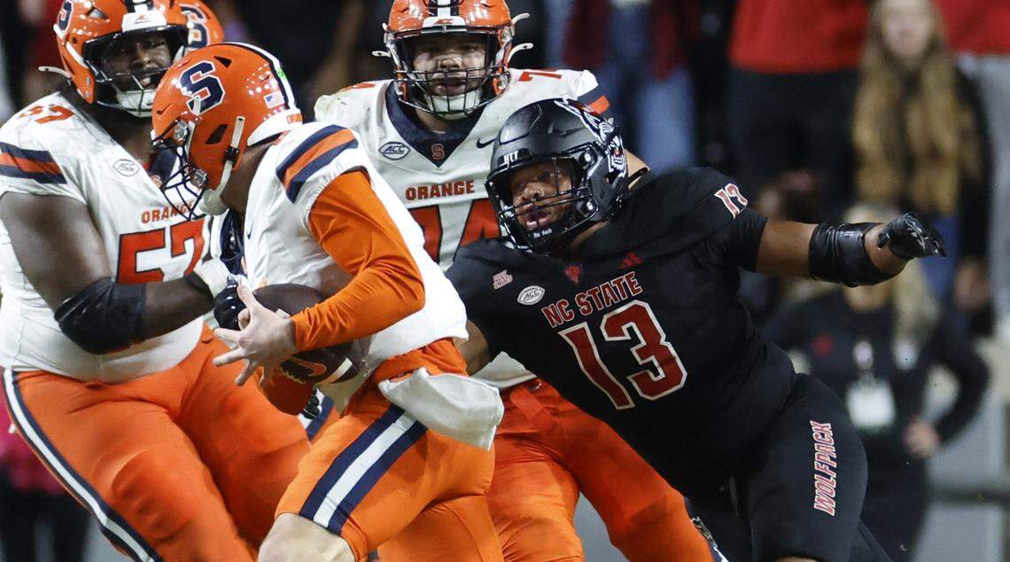 N.C. State defensive end Travali Price (13) sacks Syracuse quarterback Kyle McCord (6) during the first half of N.C. State’s game against Syracuse at Carter-Finley Stadium in Raleigh, N.C., Saturday, Oct. 12, 2024.