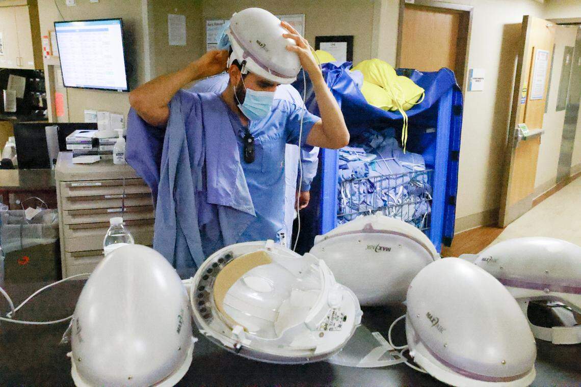 Eric Gonzalez, RN, puts on protective gear before entering the COVID patient care area of the Medical Intensive Care Unit at UNC Hospital in Chapel Hill, N.C. Wednesday, Aug. 11, 2021.