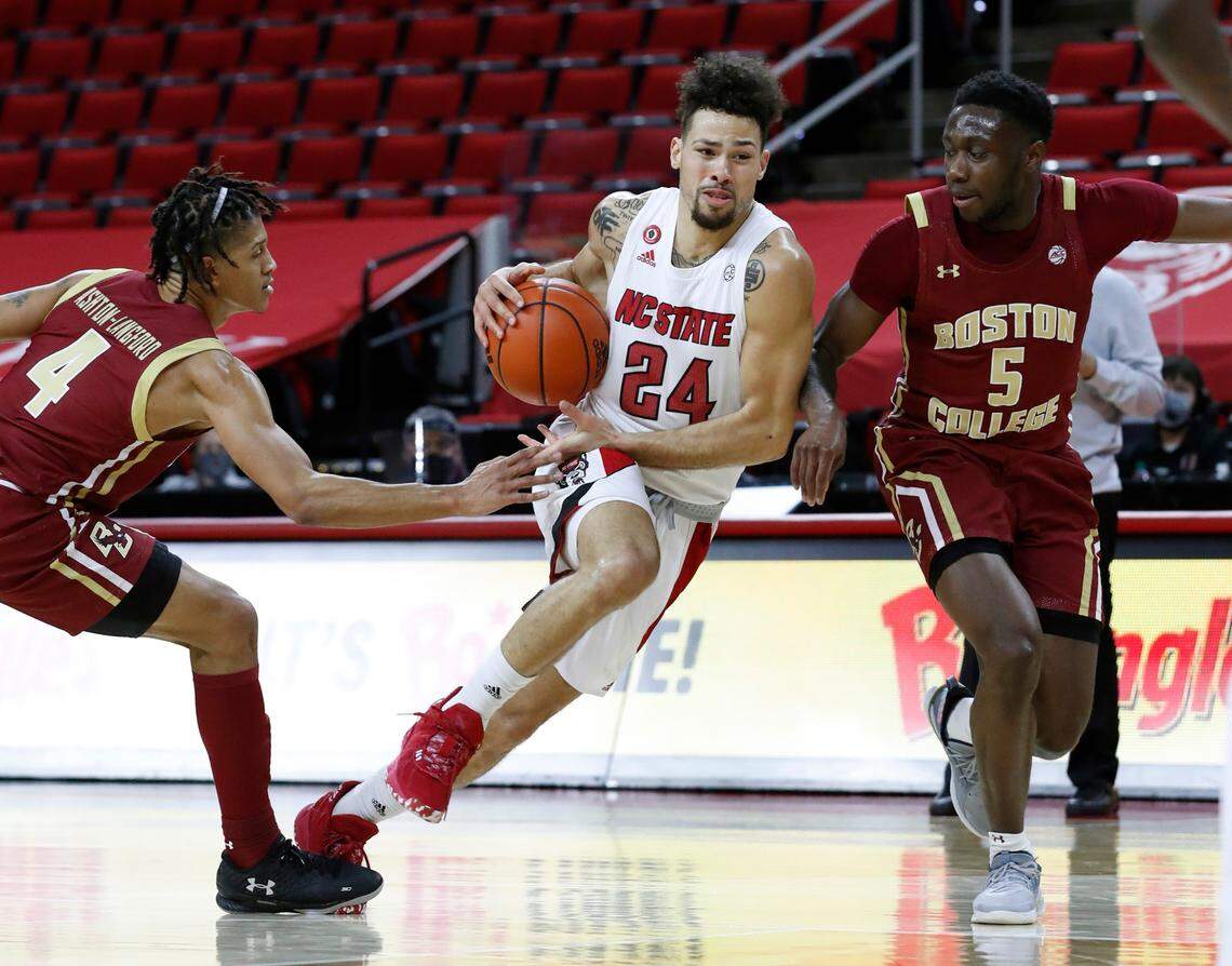 N.C. State’s Devon Daniels (24) drives between Boston College’s Makai Ashton-Langford (4) and Jay Heath (5) during the second half of N.C. State’s 79-76 victory over Boston College at PNC Arena in Raleigh, N.C., Wednesday, December 30, 2020.