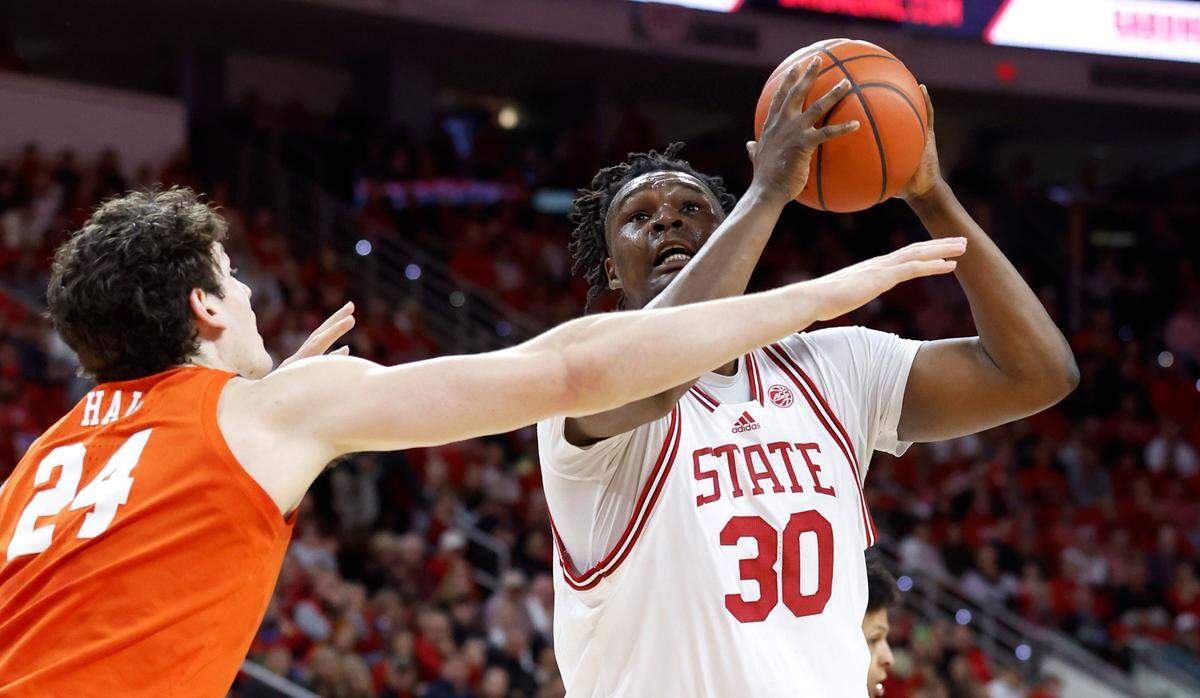 N.C. State’s D.J. Burns Jr. (30) shoots as Clemson’s PJ Hall (24) defends during the first half of N.C. State’s game against Clemson at PNC Arena in Raleigh, N.C., Saturday, Feb. 25, 2023.
