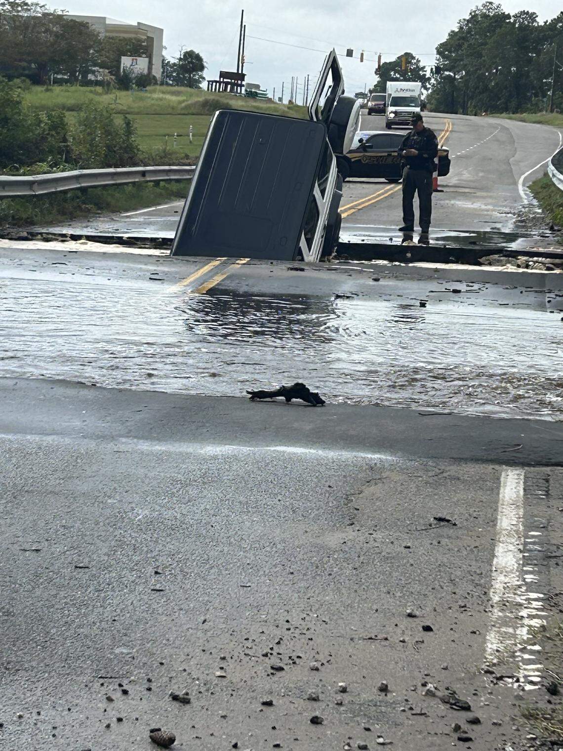 A vehicle upended in a washed out section of NC 211 in between Dosher Cut Off and River Mist subdivision in Brunswick County, N.C., Monday, Sept. 16, 2024.
