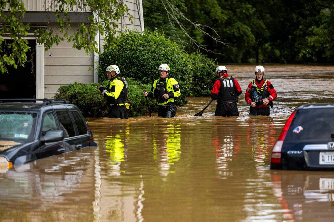 A water rescue unit with the Durham Fire Department knocks on doors at Rippling Streams Townhomes in the Old Farm neighborhood along the Eno River in Durham on Monday morning, July 7, 2025, after flash flooding caused by Tropical Storm Chantal.