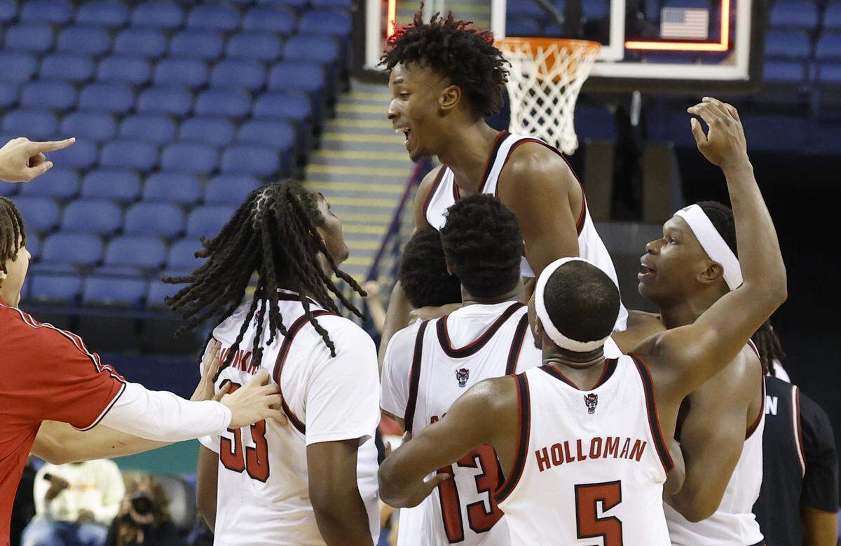 The team lifts up N.C. State's Paul McNeil Jr. (2) after he hit the game winning three-pointer to give the Wolfpack an 88-86 exhibition victory over South Carolina at the First Horizon Coliseum in Greensboro, N.C., Sunday Oct. 26, 2025.