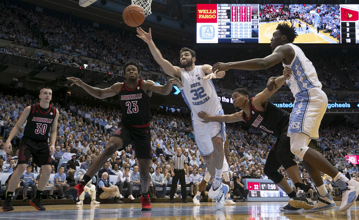 North Carolina’s Luke Maye (32) looses the ball out of bund under defensive pressure from Louisville’s Christen Cunningham (1) and Steven Enoch (23) during the first half on Saturday, January 12, 2019 at the Smith Center in Chapel Hill, N.C.