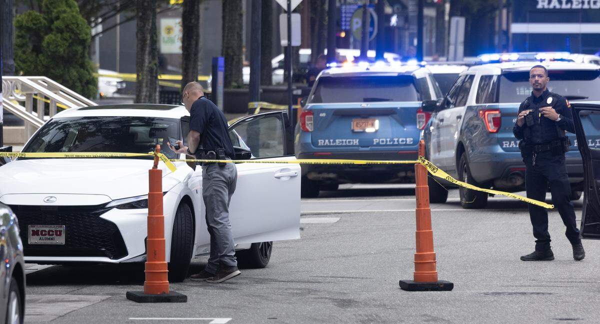 An investigator photographs the vehicle identification number (VIN) from a vehicle thought to be involved in the shooting of two people by the Wake County Courthouse in downtown Raleigh, Friday, May 22, 2026.