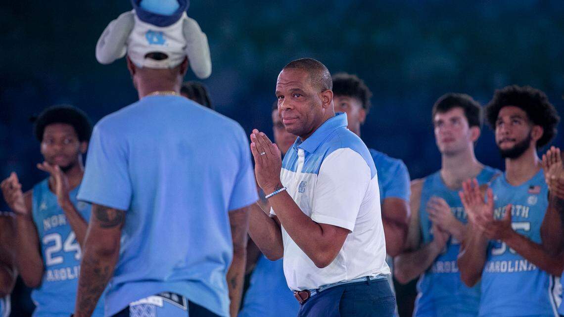 North Carolina coach Hubert Davis applauds Brian McLaughlin, the host of the annual Carolina Basketball Late Night Event to start the 2021-22 basketball season on Friday, October 15, 2021 at the Smith Center in Chapel Hill, N.C.