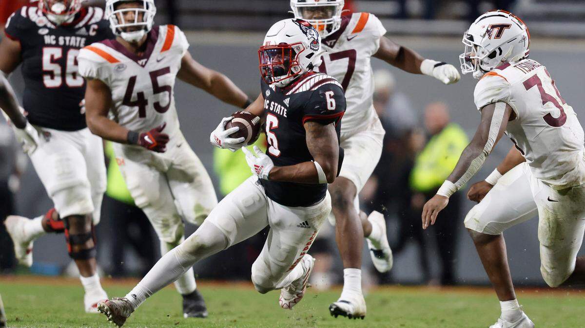 N.C. State’s Trent Pennix (6) gains yards as Virginia Tech linebacker Alan Tisdale (34) looks to stop him during the second half of N.C. State’s 22-21 victory over Virginia Tech at Carter-Finley Stadium in Raleigh, N.C., Thursday, Oct. 27, 2022.