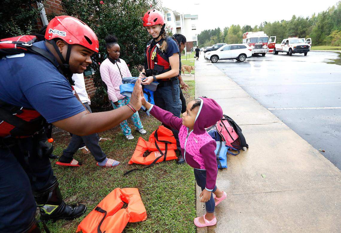 Lt. Tommy Elder Jr. with Spring Lake Fire Department high-fives a resident after helping evacuate her from the Heritage at Fort Bragg Apartments in Spring Lake, N.C., Monday Sept. 17, 2018.
