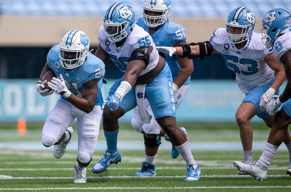 North Carolina defensive lineman Tomari Fox (56) stops running back Elijah Green (21) during the Tar Heels’ spring football game on Saturday, April 15, 2023 at Kenan Stadium in Chapel Hill, N.C.
