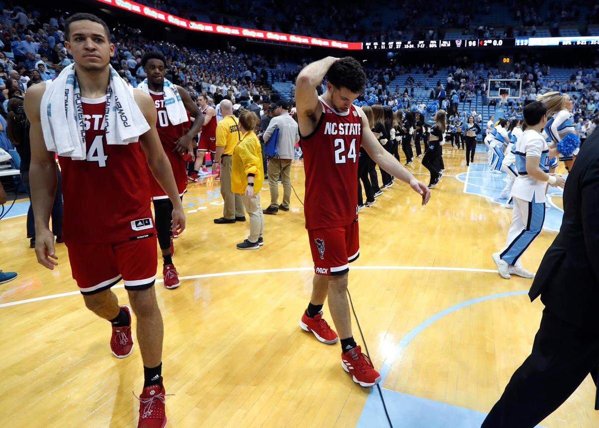 N.C. State’s Devon Daniels (24), center, and Jericole Hellems (4) walk off the court after UNC’s 113-96 victory over N.C. State at the Smith Center in Chapel Hill, N.C. Tuesday, Feb. 5, 2019.