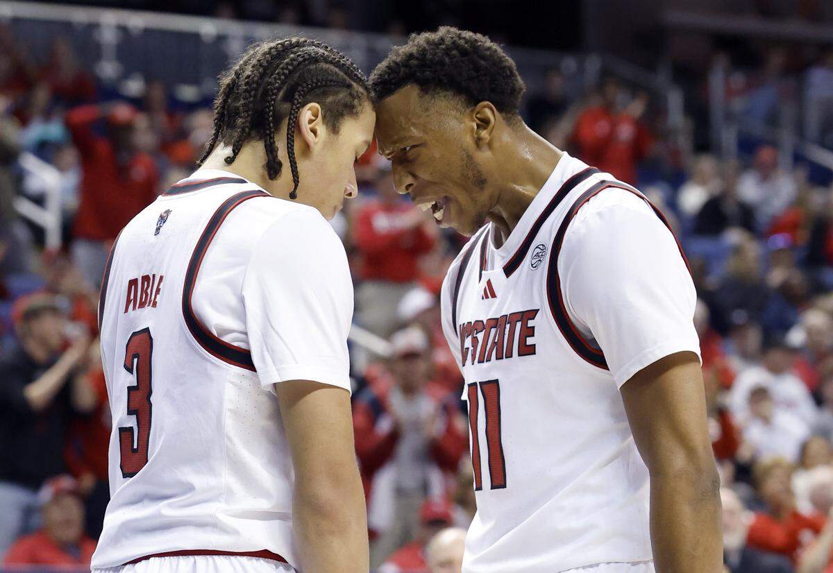 N.C. State's Quadir Copeland (11) celebrates with Matt Able (3) after Able slammed in two in the first half of  N.C. State’s exhibition game against South Carolina at the First Horizon Coliseum in Greensboro, N.C., Sunday Oct. 26, 2025.