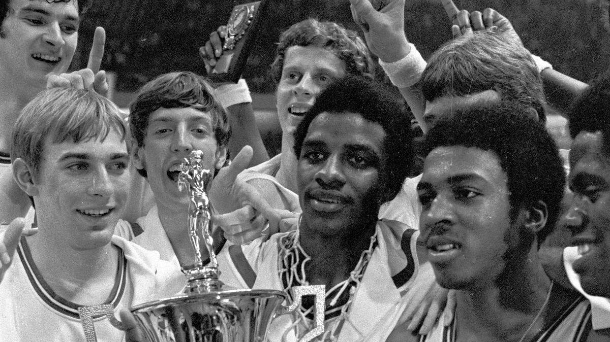 NC State players celebrate with the ACC Tournament championship trophy after their win in 1974.