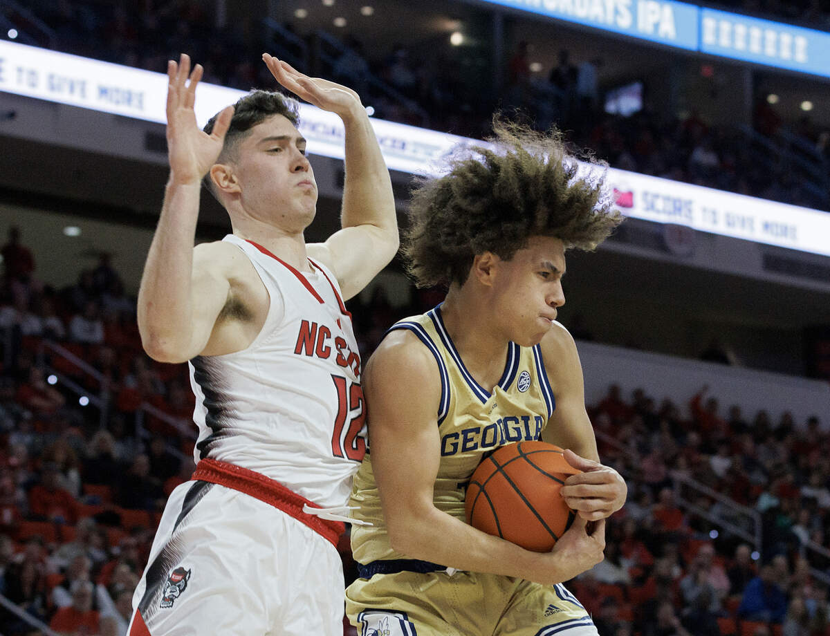 Georgia Tech’s Naithan George pulls down a rebound in front of N.C. State’s Michael O’Connell during the first half of the Wolfpack’s 82-76 win on Saturday, Feb. 3, 2024, at PNC Arena in Raleigh, N.C.
