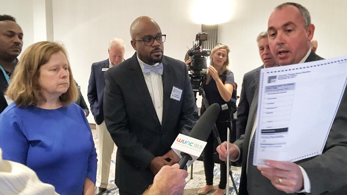 Mac Beeson, right, a regional vice president for Election Systems & Software, demonstrates the company’s voting system to State Board of Elections members Stella Anderson and Jeff Carmon.