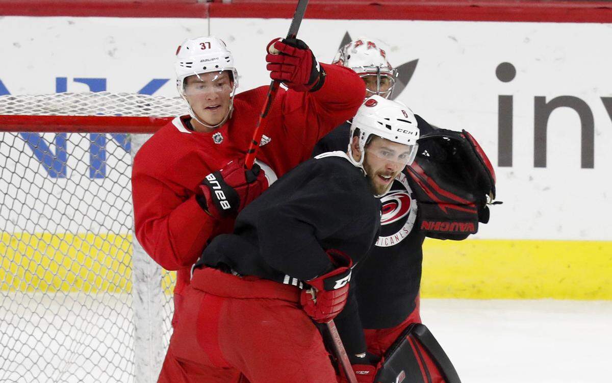 Carolina right wing Andrei Svechnikov (37) tries to get position on Joel Edmundson (6) during the Carolina Hurricanes’ on-ice workout at PNC Arena in Raleigh, N.C., Monday, July 13, 2020.