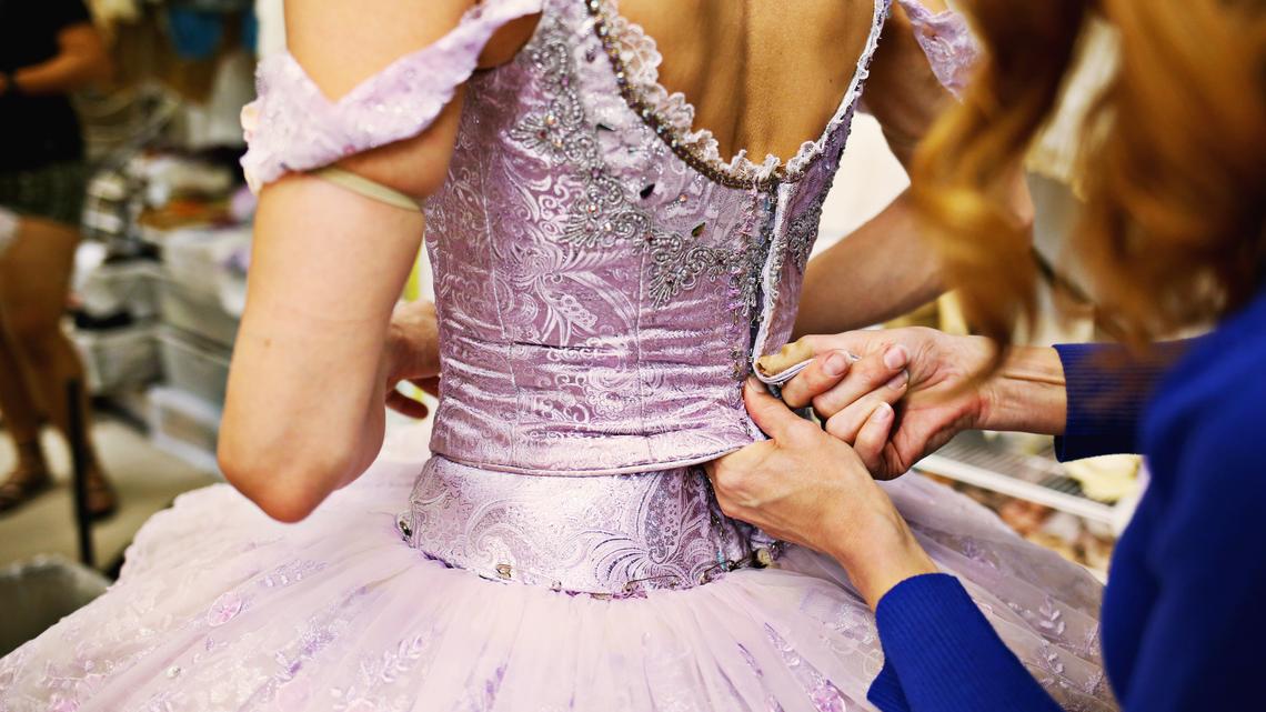 Carolina Ballet soloist Randi Osetek, left, stops by for a costume fitting between practice for "Sleeping Beauty" with costume director Kerri Martinsen, far right, May 7, 2018.