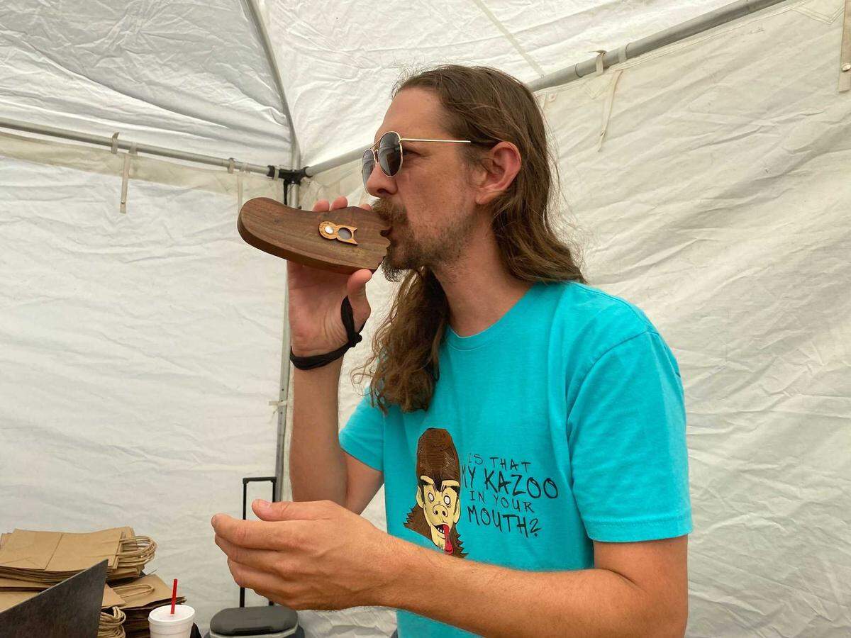 David English and his wife, Lorie, own Junkman’s Crossroads, one of the vendors at the World of Bluegrass Festival in downtown Raleigh on Saturday, Oct. 2, 2021. David English makes wooden kazoos.