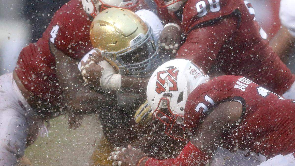 N.C. State’s Jerod Fernandez (4), B.J. Hill (98) and Jarius Morehead (31) tackle Notre Dame running back Josh Adams (33) during the first half of the Wolfpack’s game against Notre Dame at Carter-Finley Stadium in Raleigh, N.C., Saturday, Oct. 8, 2016.