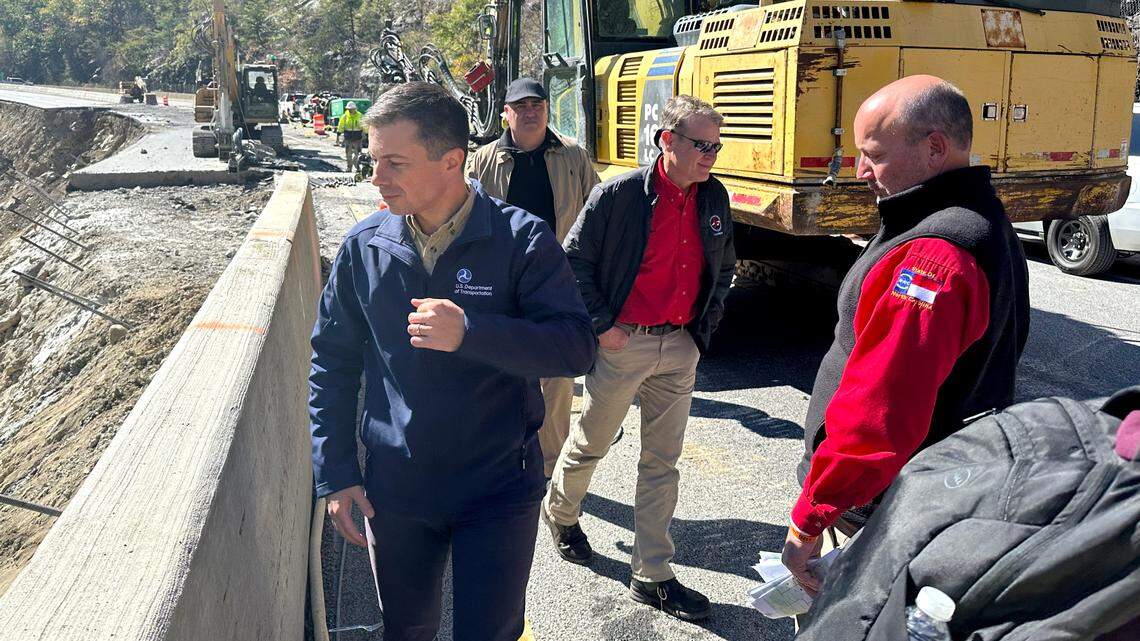 U.S. Transportation Secretary Pete Buttigieg visits Interstate 40 in Pigeon River Gorge on Thursday, Oct. 17, 2024. Buttigieg is standing at the median, where the eastbound lanes collapsed into the river after the remnants of Hurricane Helene dropped historic amounts of rain, severing the busiest connection between North Carolina and Tennessee.