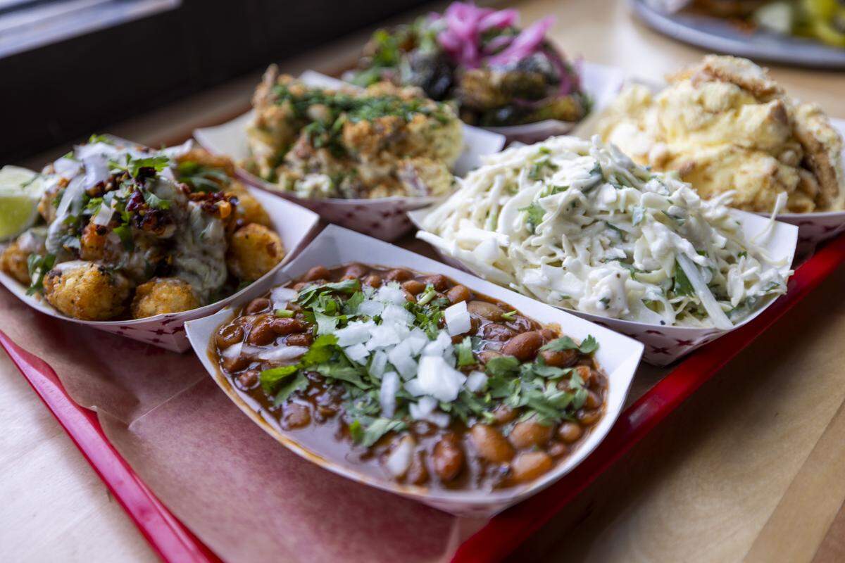 Side dishes include barbecue beans, which have pieces of brisket, slaw, potato salad and tots.