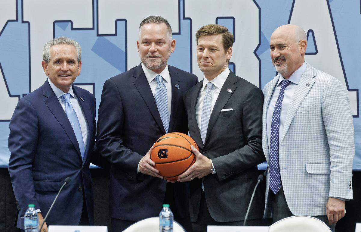 New North Carolina men’s basketball head coach Michael Malone poses for a photograph with athletic director Bubba Cunningham, chancellor Lee Roberts and incoming athletic director Steve Newmark during a press conference at the Smith Center on Tuesday, April 7, 2026, in Chapel Hill, N.C. 