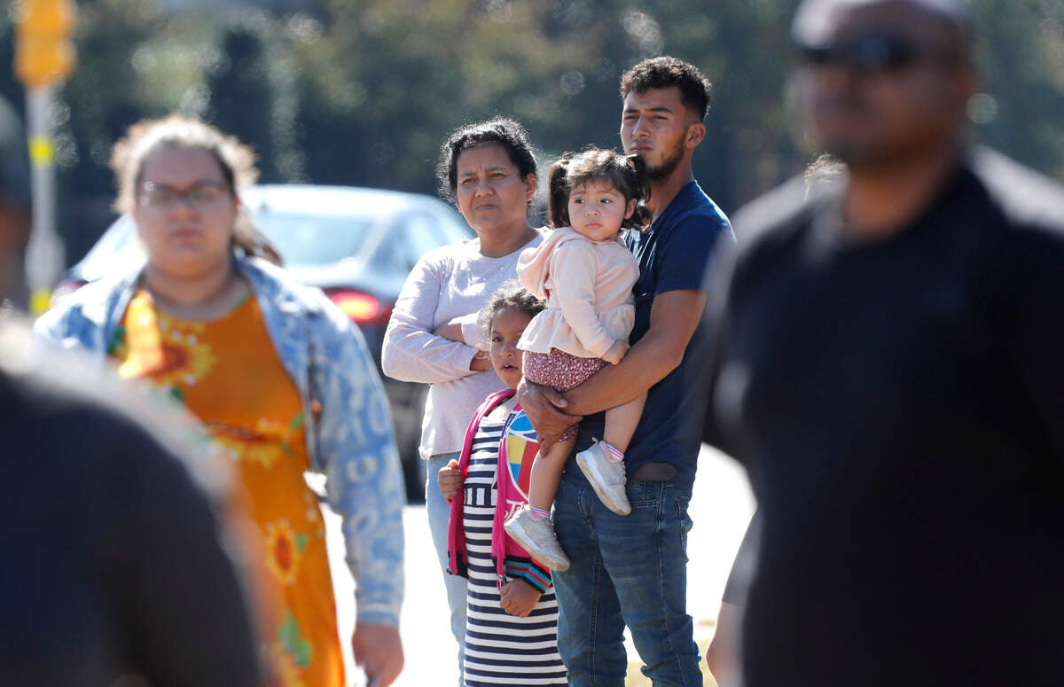 People watch as a funeral procession for Raleigh Police Officer Gabriel Torres passes them on New Bern Ave. while on its way to Brown-Wynne funeral home in Raleigh Saturday, Oct. 22, 2022. Officer Torres was killed in a mass shooting Oct. 13