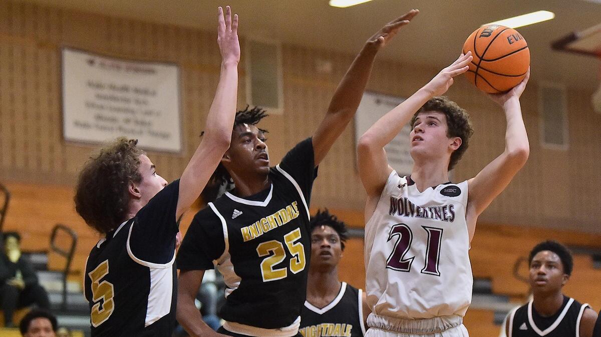 Wakefield’s Liam Witchey (21) shoots against Knightdale’s Nick Boone (5) and Ayinde Taylor (25) during the first quarter. The Knightdale Knights and the Wakefield Wolverines met in a first round NCHSAA 4A playoff game in Raleigh, N.C. on February 25, 2020.