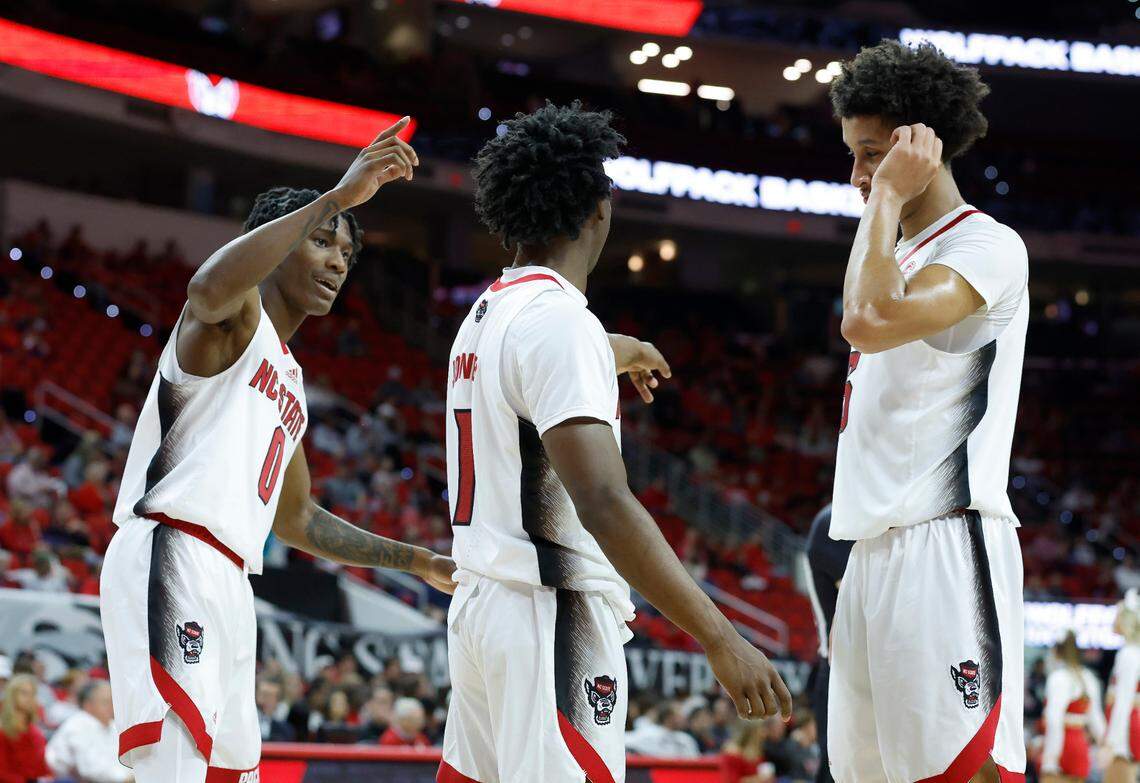 N.C. State’s Terquavion Smith (0), left, Jarkel Joiner (1), center, and Jack Clark (5) talk to each other after a timeout during the second half of N.C. State’s 74-63 victory over Elon at PNC Arena in Raleigh, N.C., Saturday, Nov. 19, 2022.