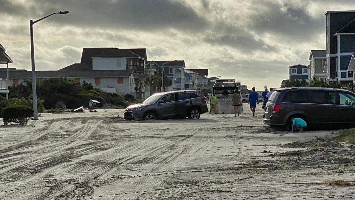 Hurricane Isaias left cars scattered on streets covered with sand on Oak Island in Brunswick County, N.C. Tuesday, Aug. 4, 2020 after making landfall there overnight.