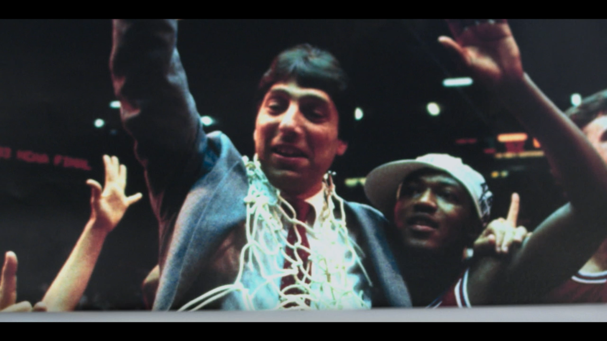 Screenshot from the Pilot episode of Apple TV+ series Ted Lasso that features a poster of legendary NC State Men’s Basketball coach Jim Valvano after winning the 1983 NCAA Men’s Basketball Championship against the University of Houston.