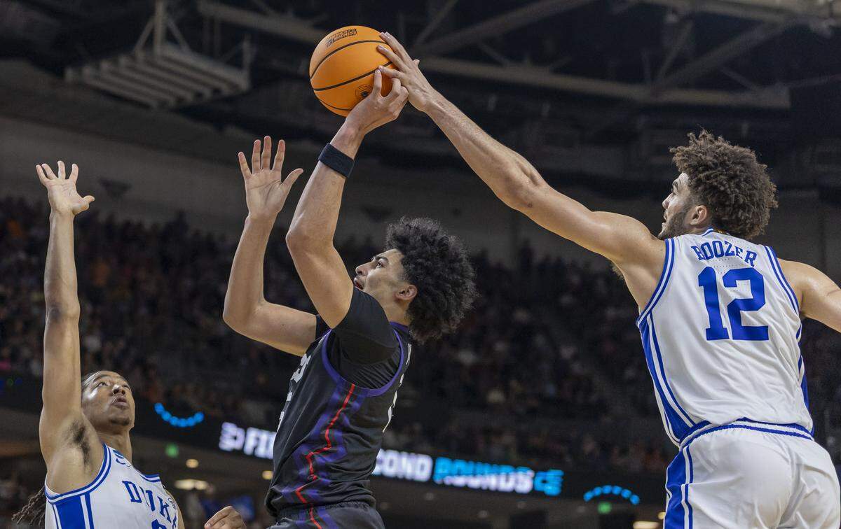 Duke forward Cameron Boozer (12) blocks a shot by TCU forward David Punch (15) in the second half on Saturday, March 21, 2026, during the second round of the NCAA Tournament at Bon Secours Arena in Greenville, S.C.