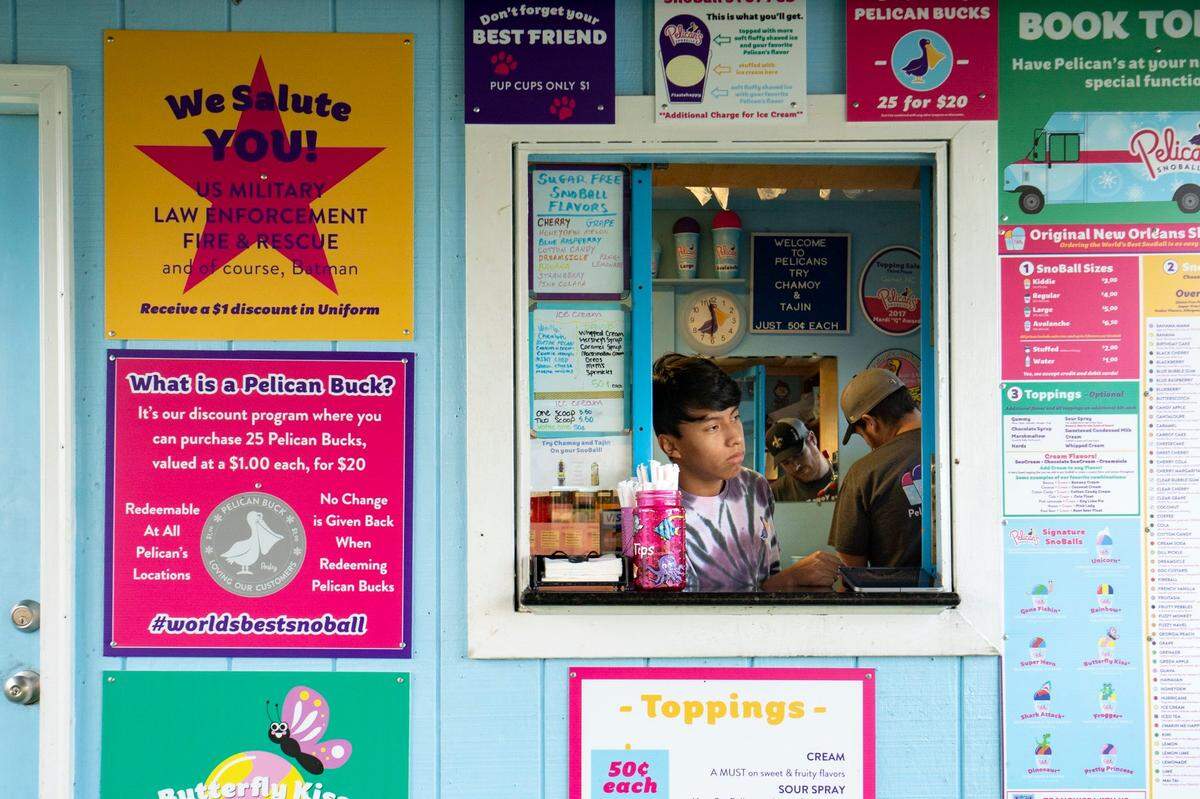Benjamin Devlin and Austin Johnson work to fill a customer’s order at the Pelicans Snoballs stand located at 401 Par Golf in Raleigh, N.C. on Thursday, Aug. 18, 2022. Developers are planning to buy the 72 acres where Par Golf and Pelicans are located to build a master-planned residential and commercial community.