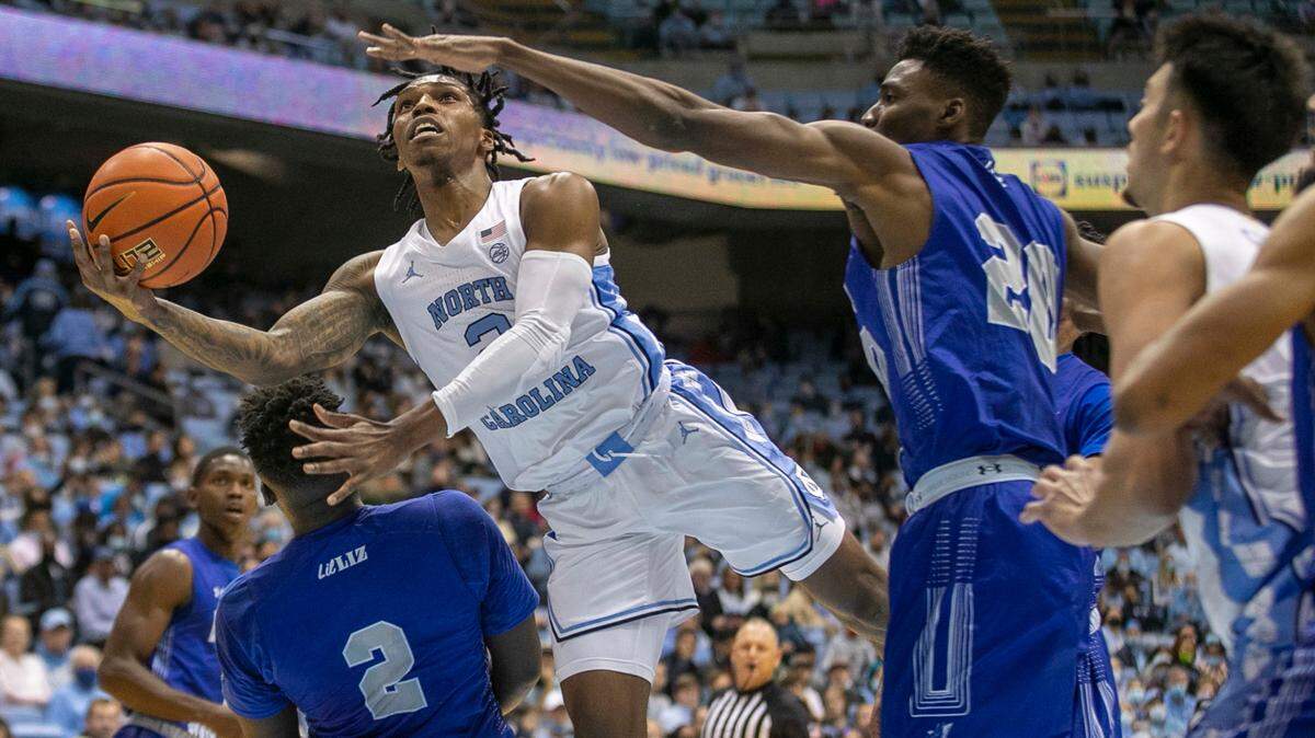 North Carolina’s Caleb Love (2) drives to the basket between Elizabeth City State’s Sai Fisher (2) and Anthony DoDoo (20) during the first half on Friday, November 5, 2021 at the Smith Center in Chapel Hill, N.C.