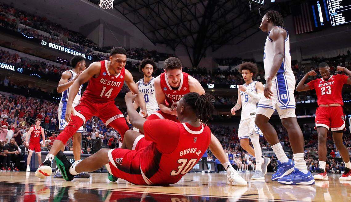 N.C. State’s Casey Morsell (14) and Michael O’Connell (12) celebrate with DJ Burns Jr. (30) after Burns made the basket while being fouled during N.C. State’s 76-64 victory over Duke in their NCAA Tournament Elite Eight matchup at the American Airlines Center in Dallas, Texas, Sunday, March 31, 2024.