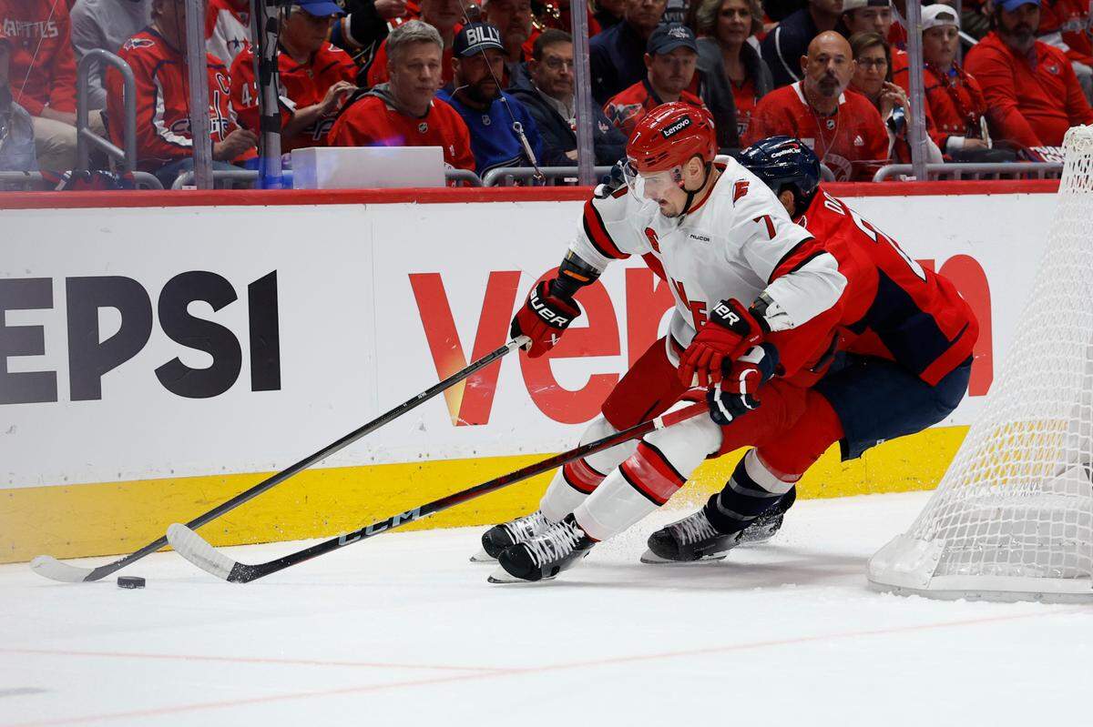 Carolina Hurricanes defenseman Dmitry Orlov (7) skates with the puck as Washington Capitals right wing Brandon Duhaime (22) defends in the first period in game two of the second round of the 2025 Stanley Cup Playoffs at Capital One Arena.