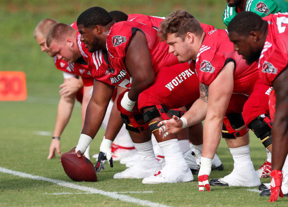 N.C. State center Grant Gibson (50), along with the offensive line including Joe Sculthorpe (71), center right, and Emanuel McGirt Jr. (74), right, warm up before the Wolfpack’s practice in Raleigh, N.C. Tuesday, August 6, 2019.