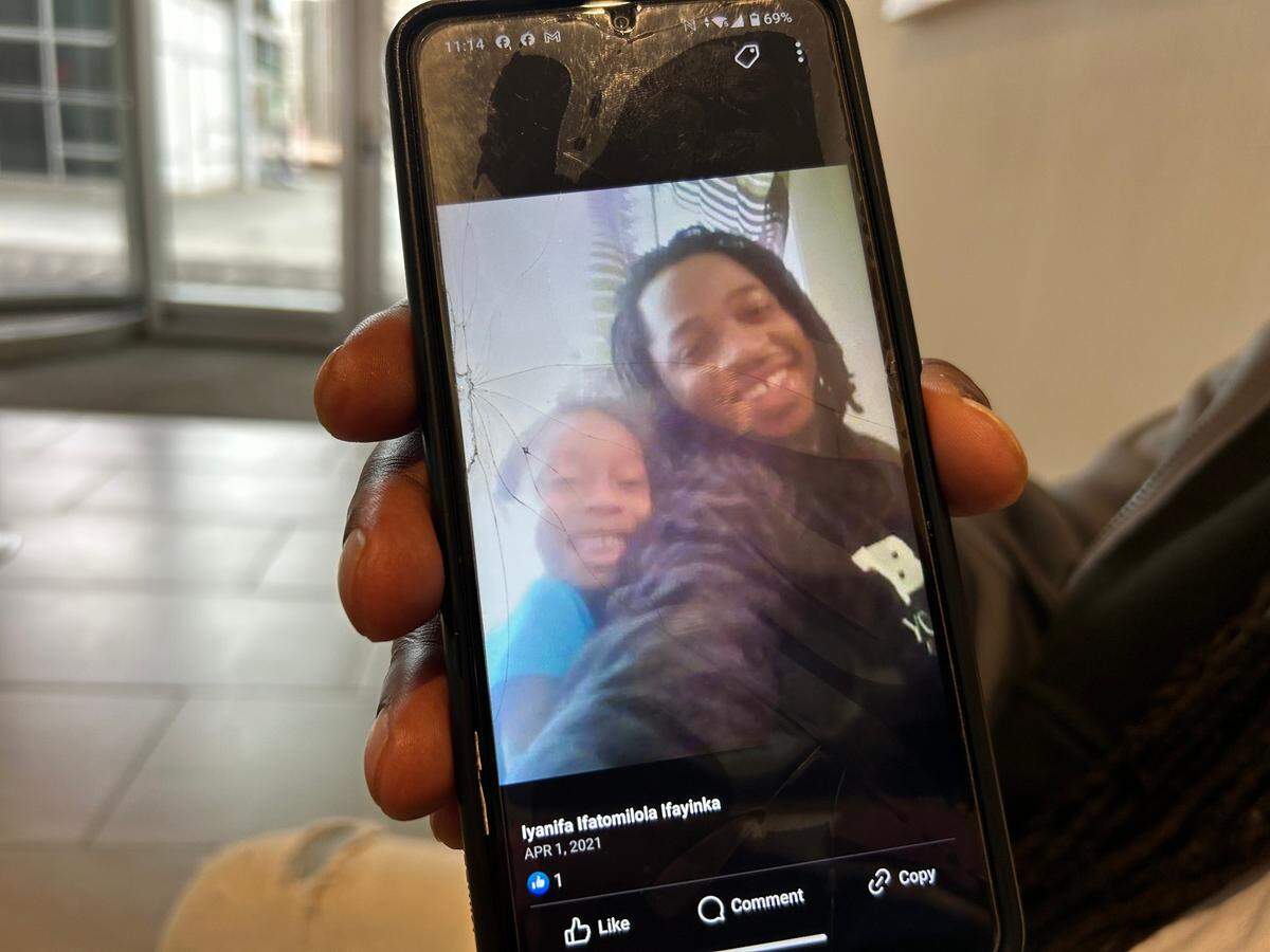 Brandon Anderson shows a cell phone photo he keeps of his friend James Alston III with his daughter.