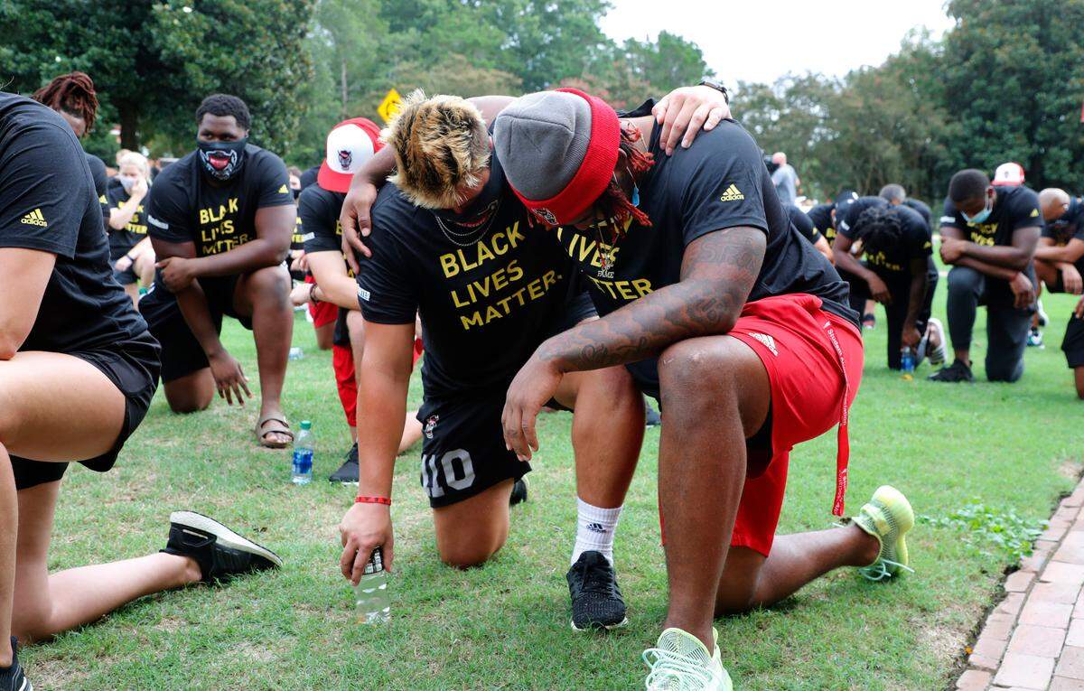 N.C. State athletes, coaches and staff kneel for 8:46, the time police kneeled on George Floyd, during a #PackUnited peaceful protest against racial and social injustice outside Holladay Hall on the campus of N.C. State Saturday, Sept. 12, 2020.