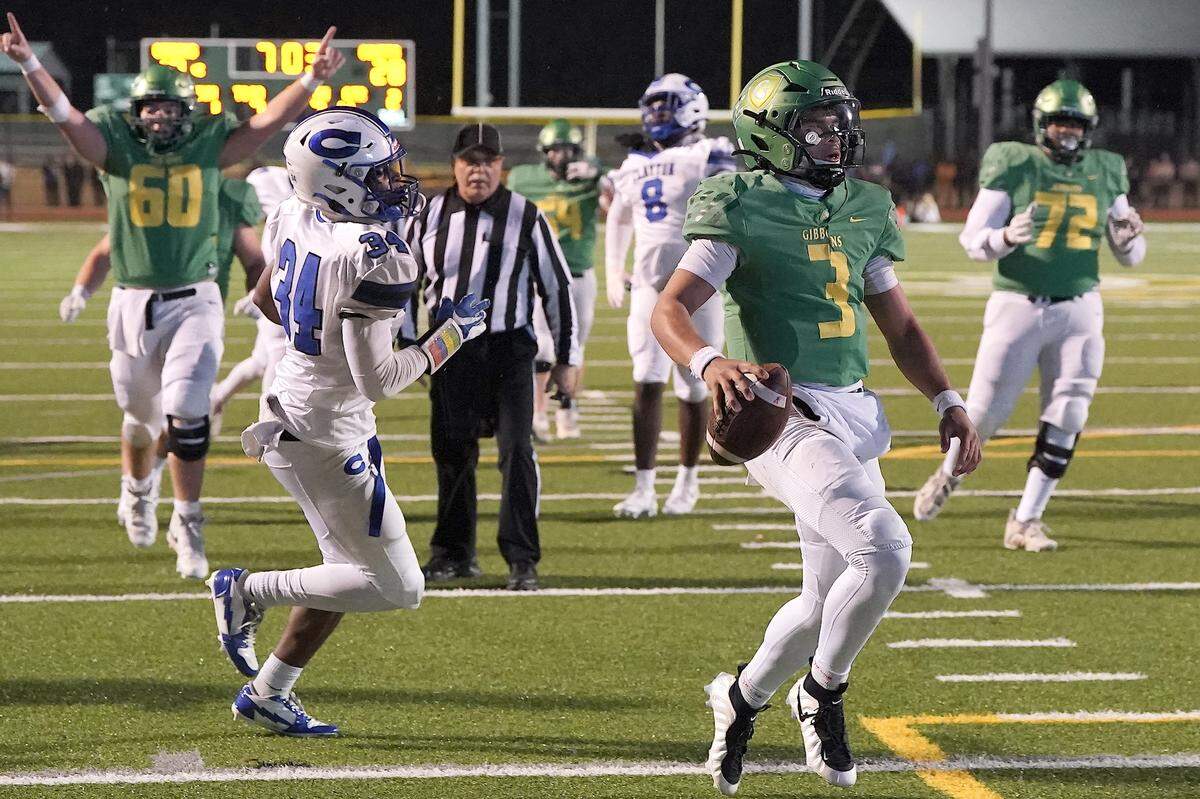 Cardinal Gibbons quarterback Gannon Jones (3) runs for the touchdown ahead of Clayton linebacker Imari Givens (34) during the second half. The Clayton Comets and the Cardinal Gibbons Crusaders met in the East Regional Final of the NCHSAA 7A Football Championship in Clayton, N.C. on December 4, 2025.