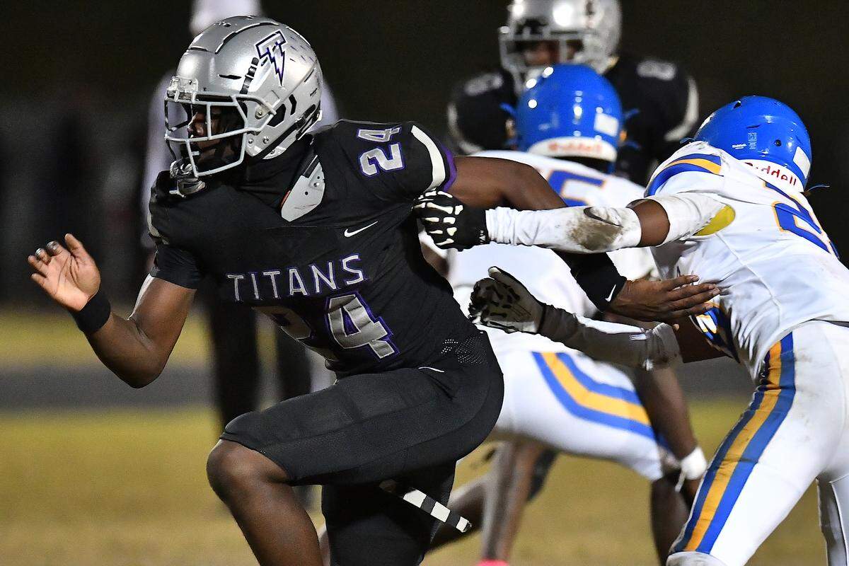 South Garner defensive end Ebenezer Ewetade (24) rushes past Garner defensive back Tristian Freeman (20) during the first half. The South Garner Titans and the Garner Trojans met in a conference football game in Raleigh, N.C. October 17, 2025